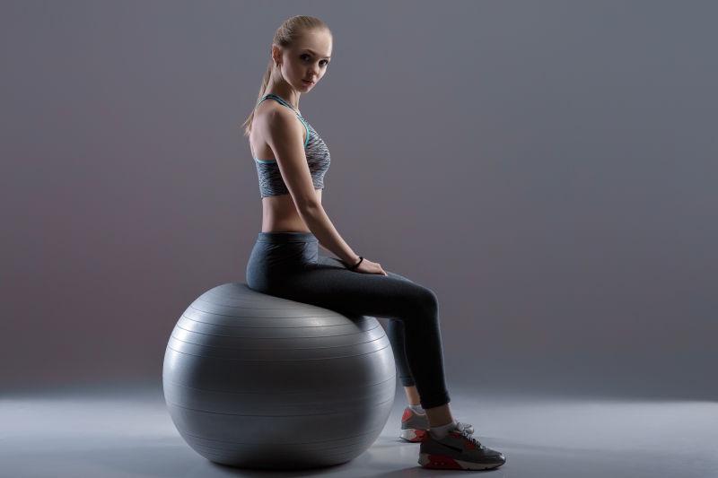 坐在健身球上锻炼的性感美女