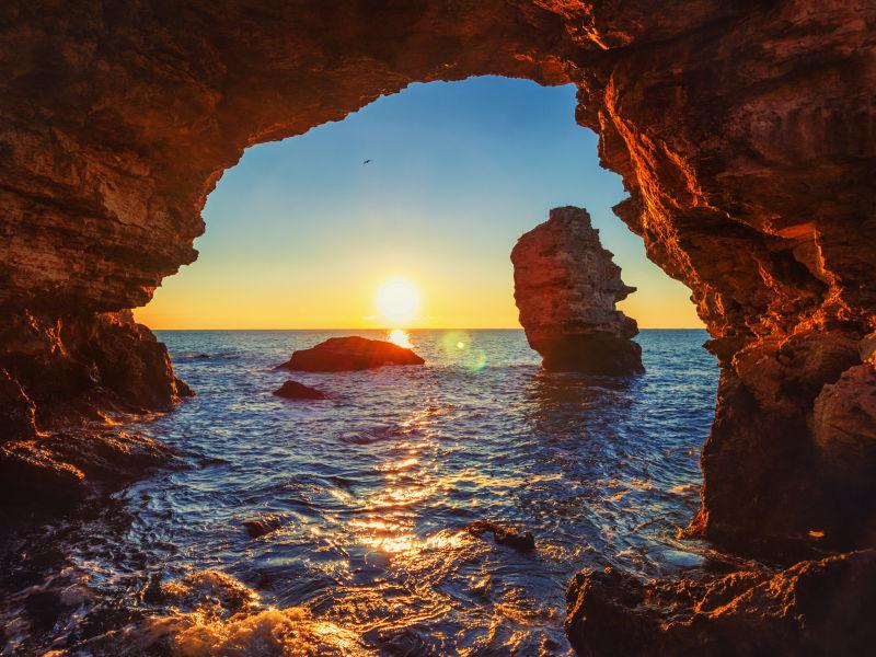 海边岩洞间的日出