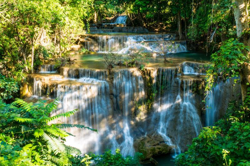 美丽的瀑布在阳光下的森林深处
