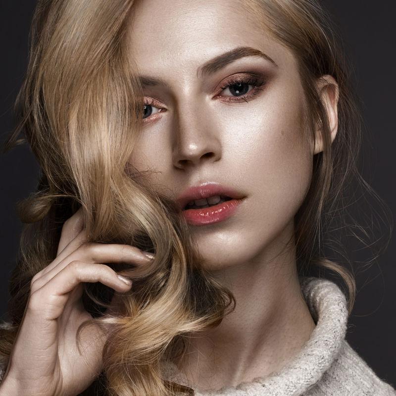 拿着自己卷发的性感美女