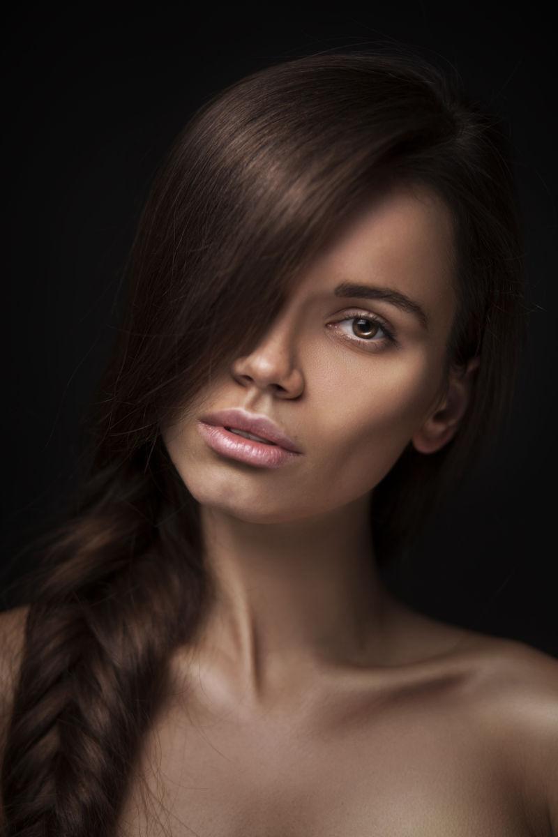 黑色背景下留着长长的黑色直发的美丽女人