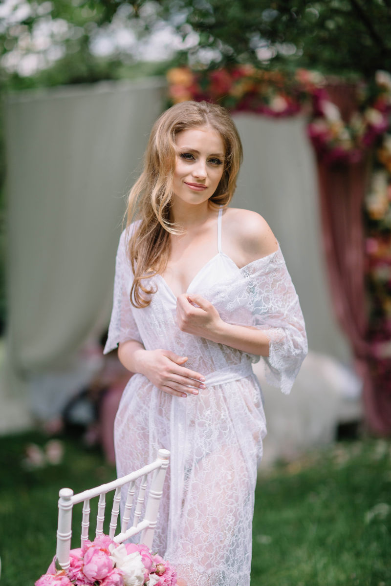 户外花园里穿着白色蕾丝衣服的美女