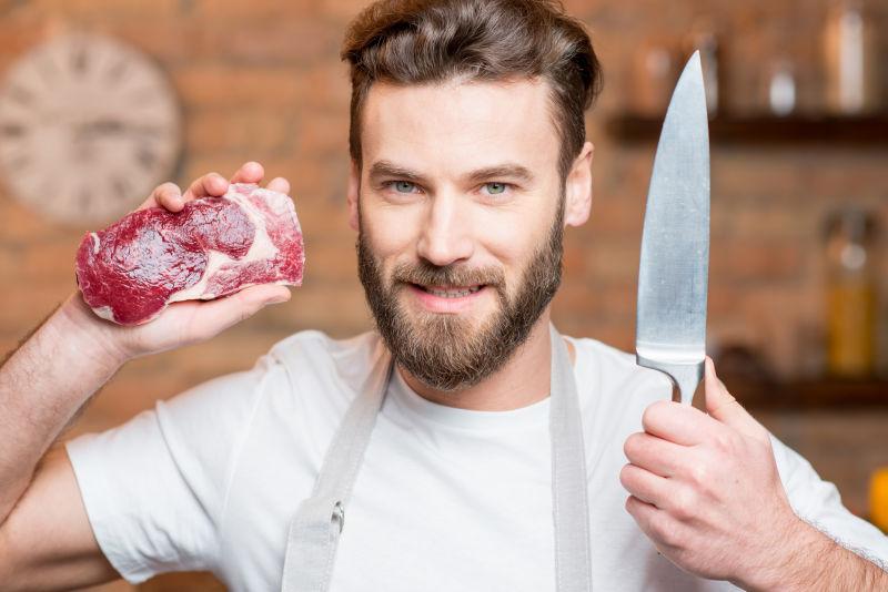 一个帅哥拿着刀子在厨房里画像