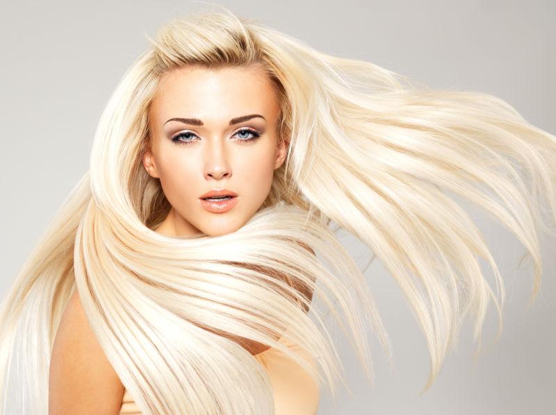 灰色背景下的金色长直发美女