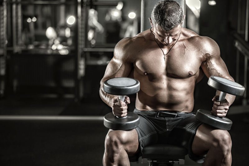 拿着哑铃健身锻炼的健壮肌肉男