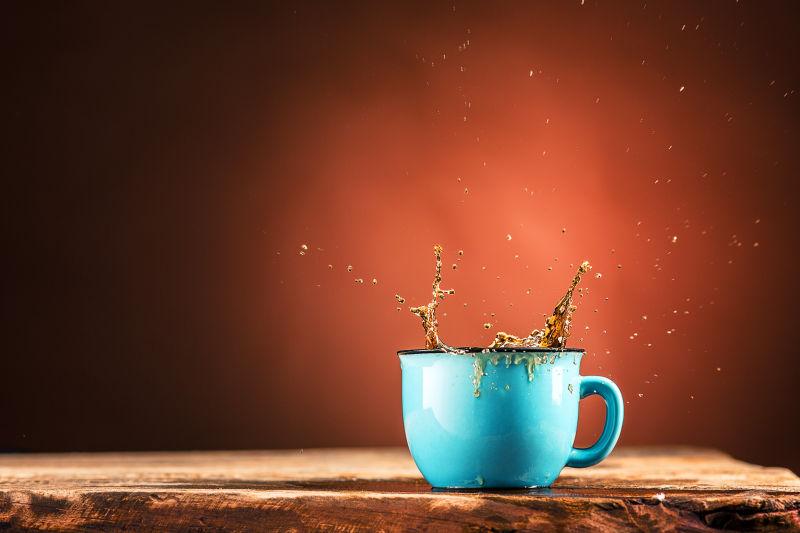 从蓝色杯子里飞溅出来的饮料