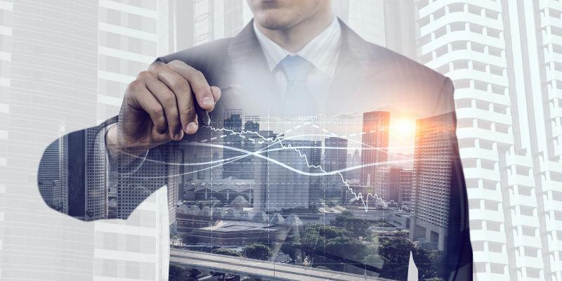 商人在映着城市背景的落地窗前的身影