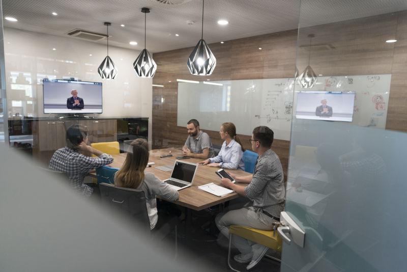 在现代办公室启动高级商务人员参加视频会议的商务人士组