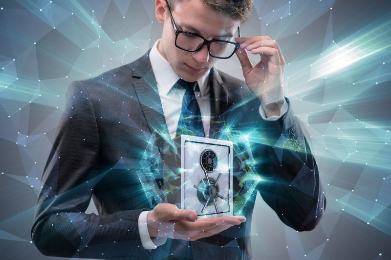 带着眼镜的商务人士拿着一个保险箱