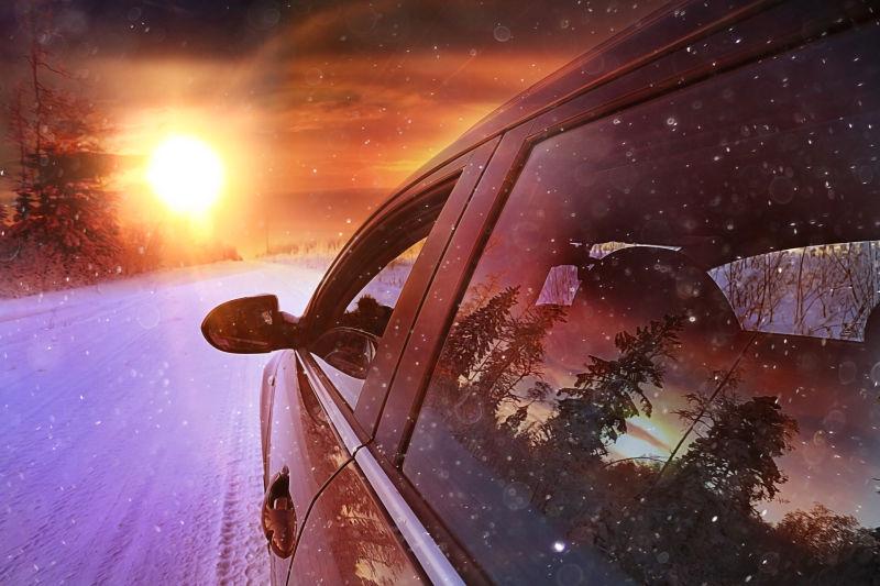 日落下雪地上行驶的车辆