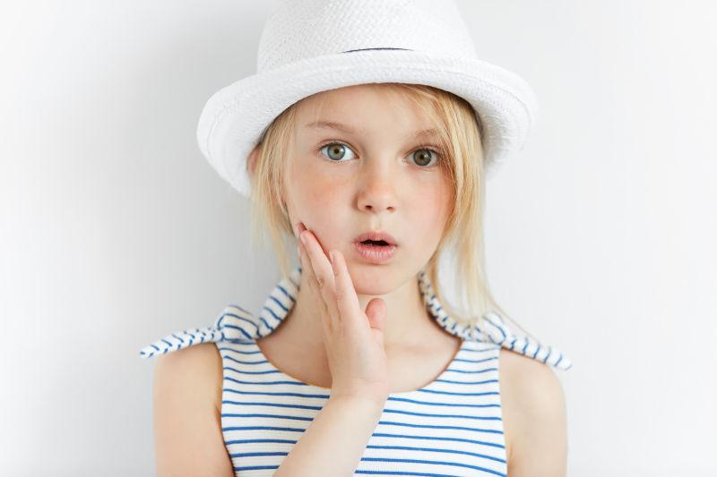 抚着自己脸颊的可爱小女孩