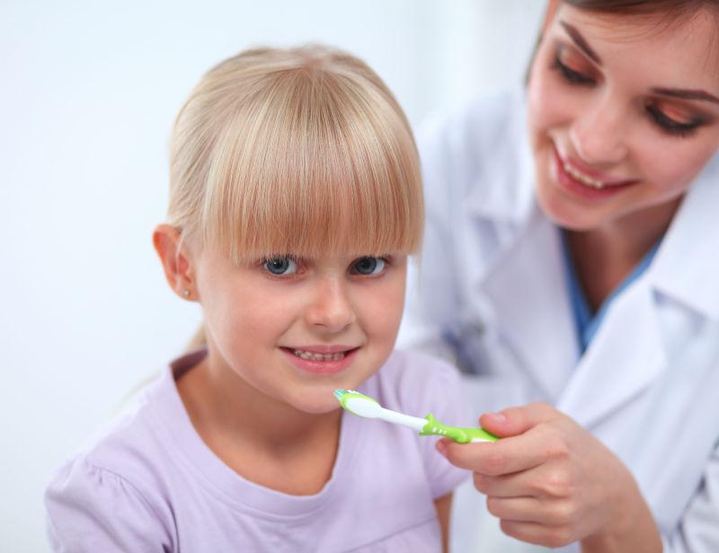 牙医给小女孩递牙刷