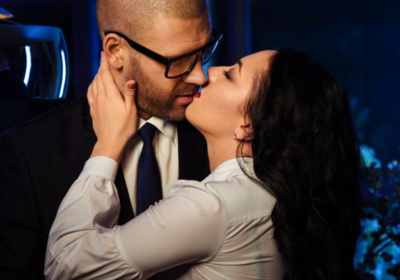 办公室里一个性感的黑发女人和英俊的商人在接吻