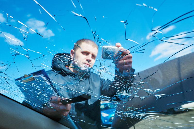 拍摄汽车破碎玻璃的男人