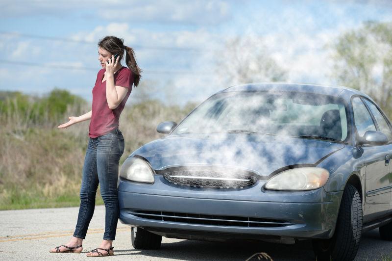 蓝天下田野旁美女站在坏了的汽车前打电话