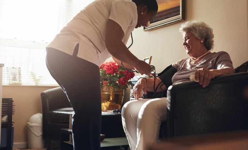 为老年人量血压的女医务人员