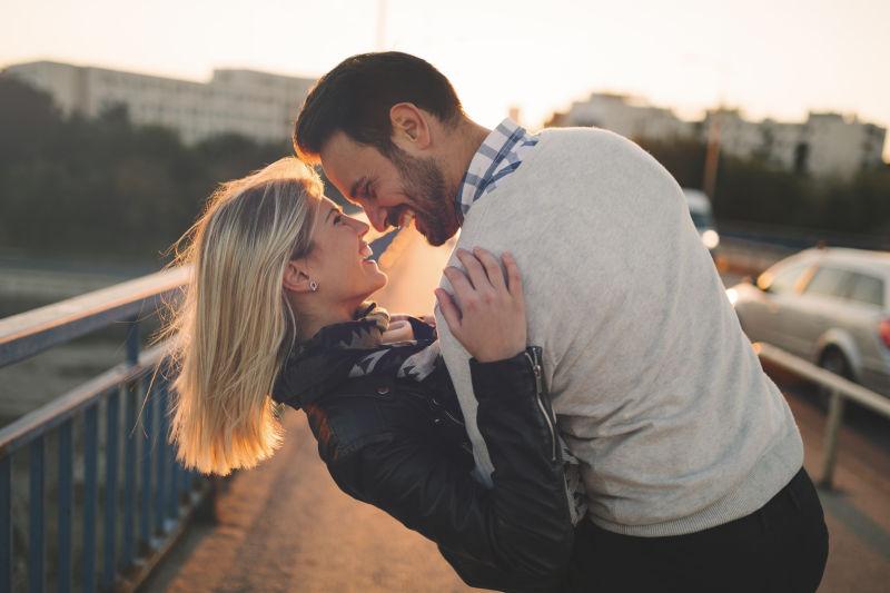 享受日落与亲吻的恋爱中的浪漫情侣