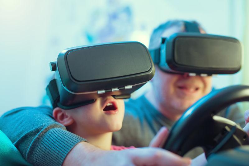 戴虚拟现实眼镜用方向盘遥控器玩游戏的父子