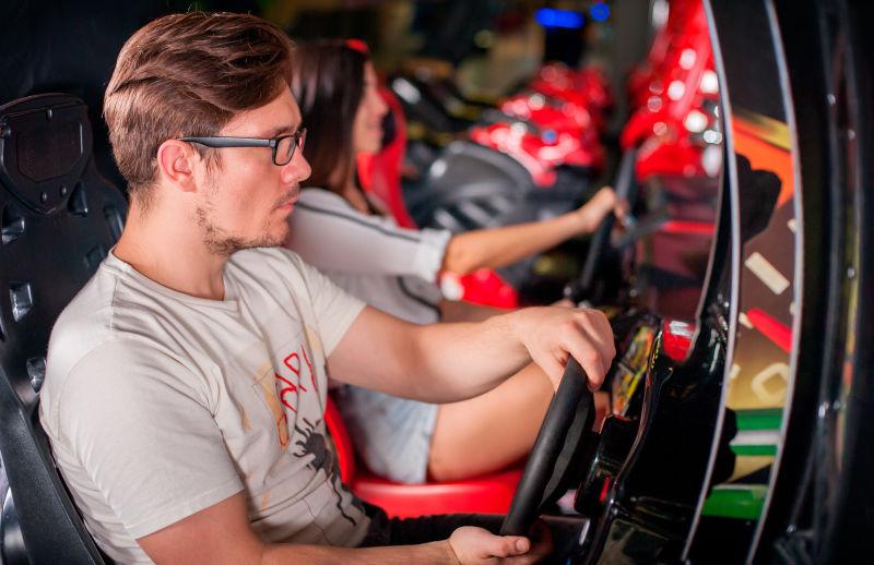 用方向盘遥控器玩游戏的年轻男子