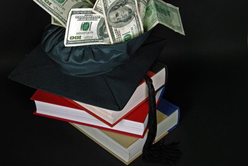 黑色背景中书本上的黑色毕业帽