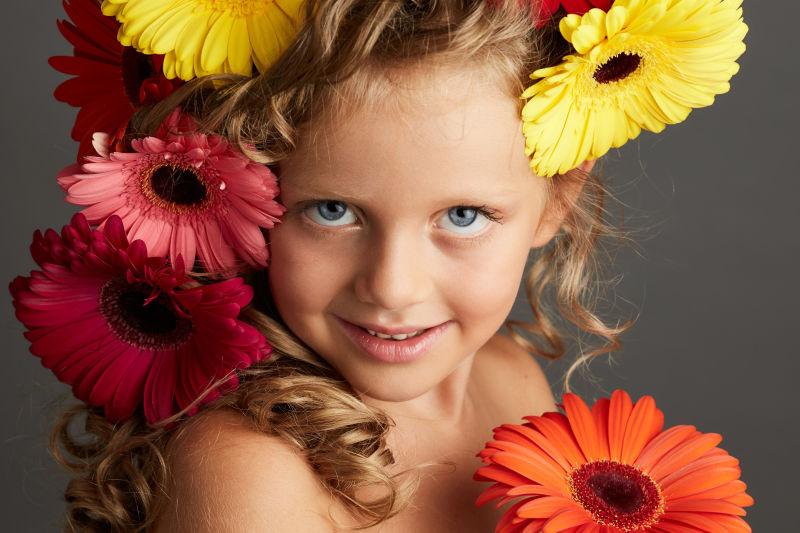 灰色背景下的小女孩和花朵