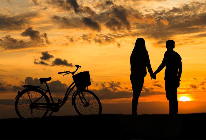 甜蜜情侣夕阳下和自行车的剪影