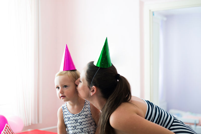 戴着生日帽子的孩子和母亲