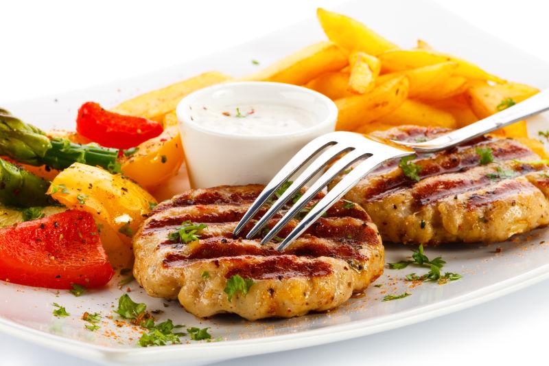 盘子里的牛排和薯条还有蔬菜沙拉