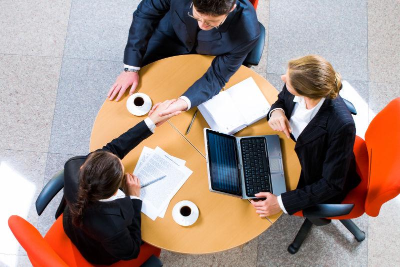 圆形办公桌边的三个商务精英