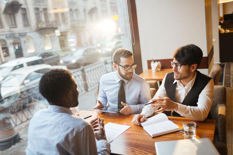 商人坐在木制咖啡桌上讨论新的商业策略