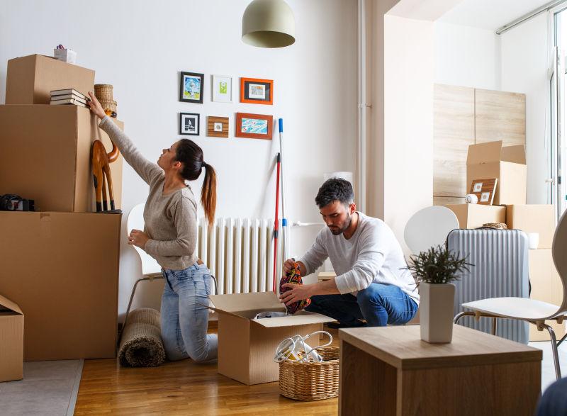 年轻夫妇拆开搬家用的纸箱