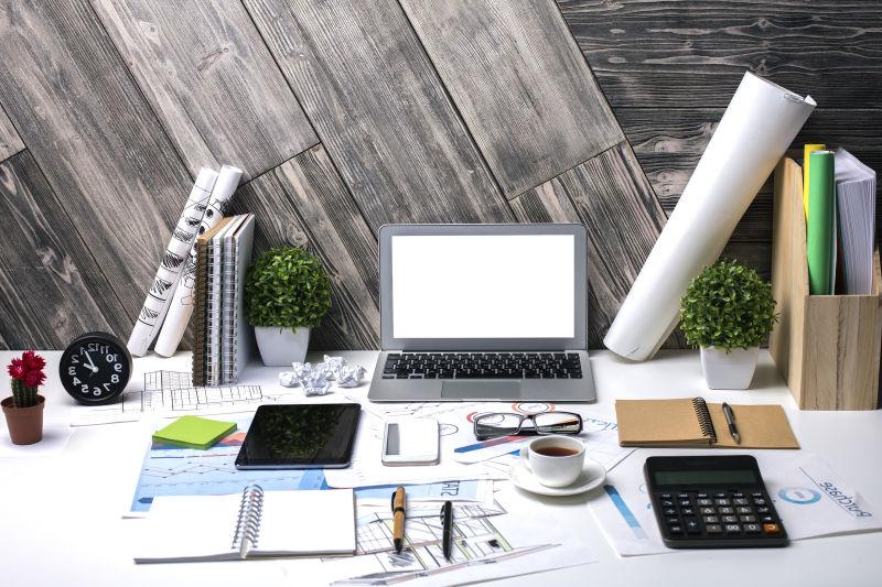 白色办工桌上的笔记本和各种办公用品