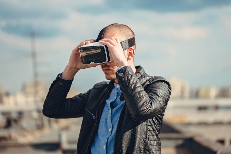 年轻男人带着VR眼镜在户外