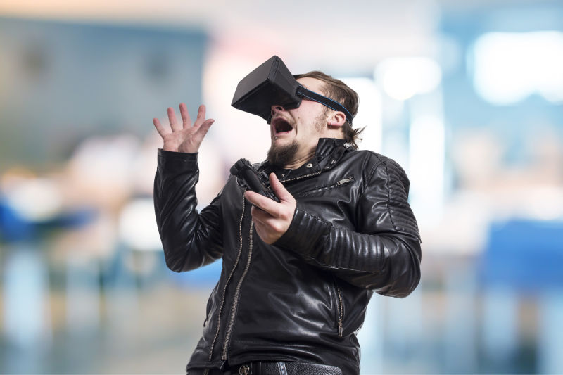 男人带着VR眼镜惊恐的玩游戏