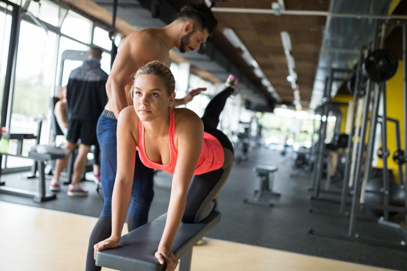 健身房里健身的女人和教练