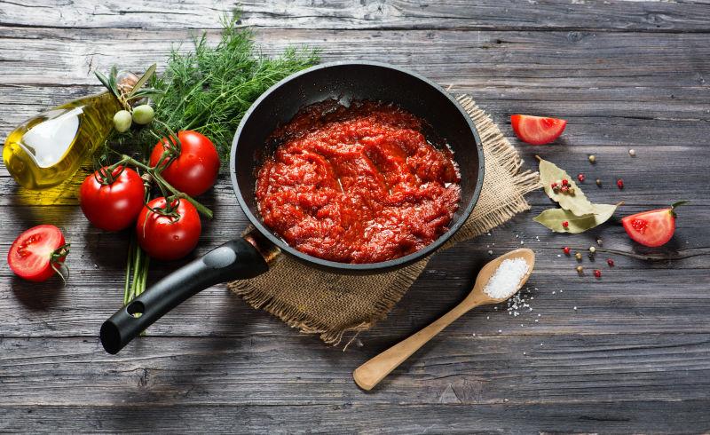 木桌上平底锅上有番茄酱