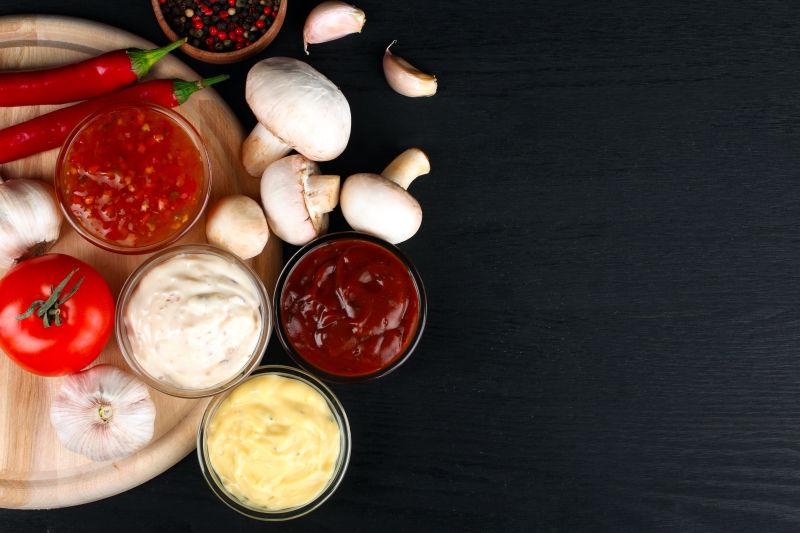 黑色木桌上的蘑菇与各种调料