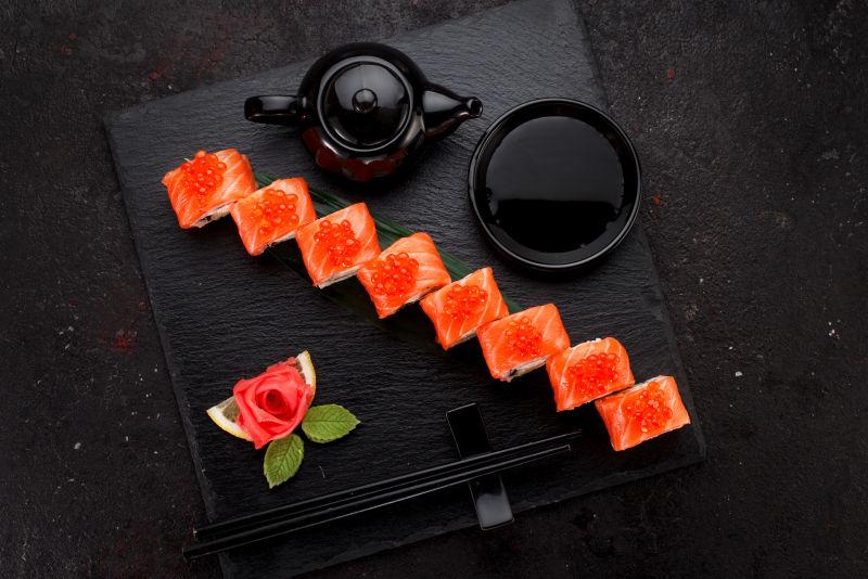 鲑鱼寿司卷在石板上的混凝土背景