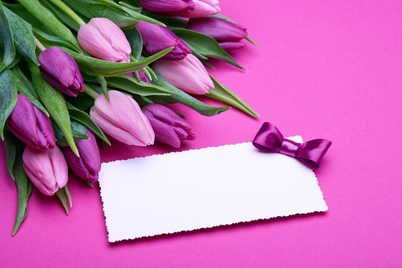 郁金香花束边装饰着蝴蝶结的白色贺卡