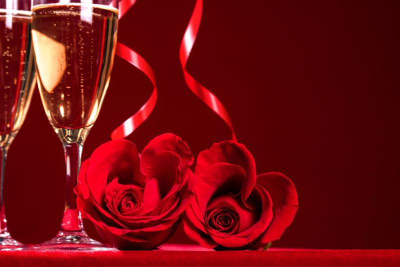 红色背景下的香槟和心形玫瑰花