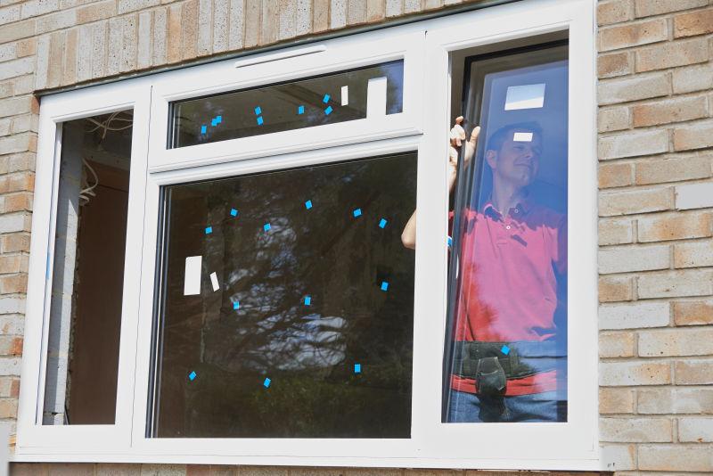 年轻建筑工人在屋内安装新窗户