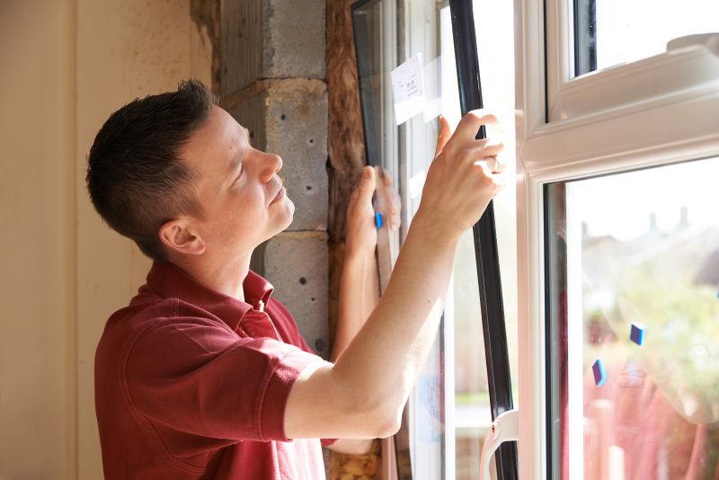 建筑工人在屋内安装新窗户