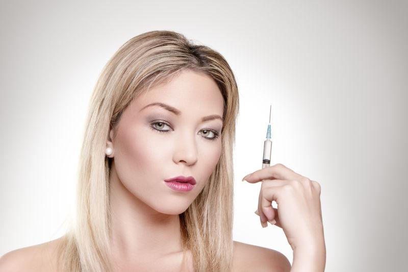 拿着注射器的美丽的女人肖像