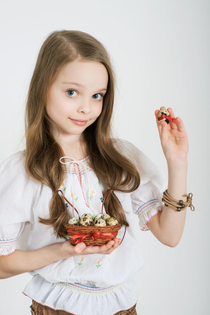 可爱的小女孩拿着装复活节彩蛋的篮子