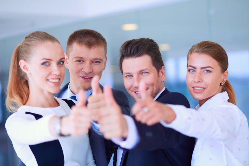 竖起大拇指的快乐的商业团队