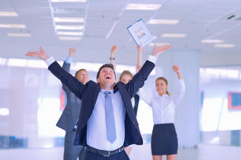 双手抛向天空庆祝胜利的业务团队