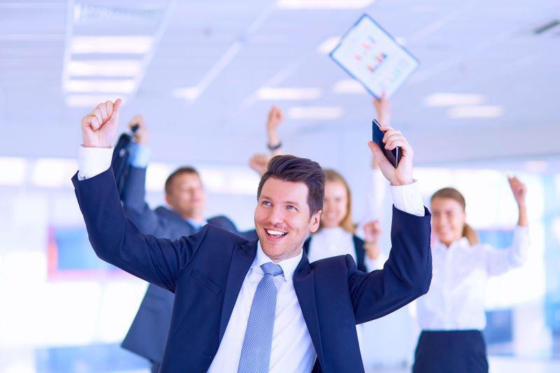 拿着庆祝胜利的武器的业务团队