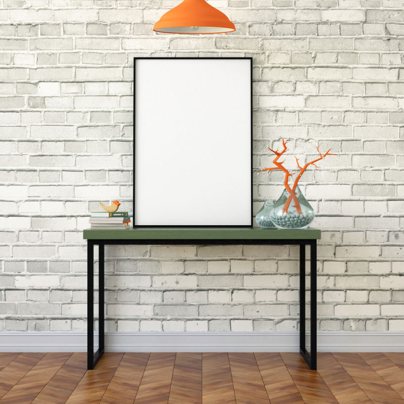 砖墙旁的办公桌上放着空白画框和书