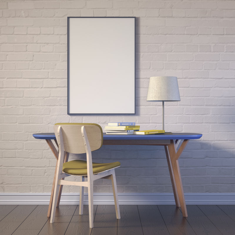 地板上的蓝色办公桌和砖墙上的空白画框