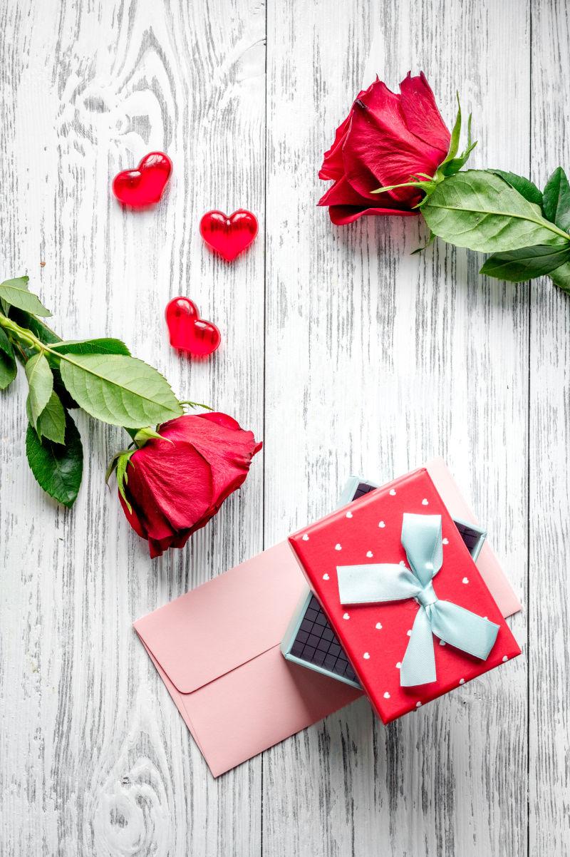玫瑰花瓣与礼盒在木桌上